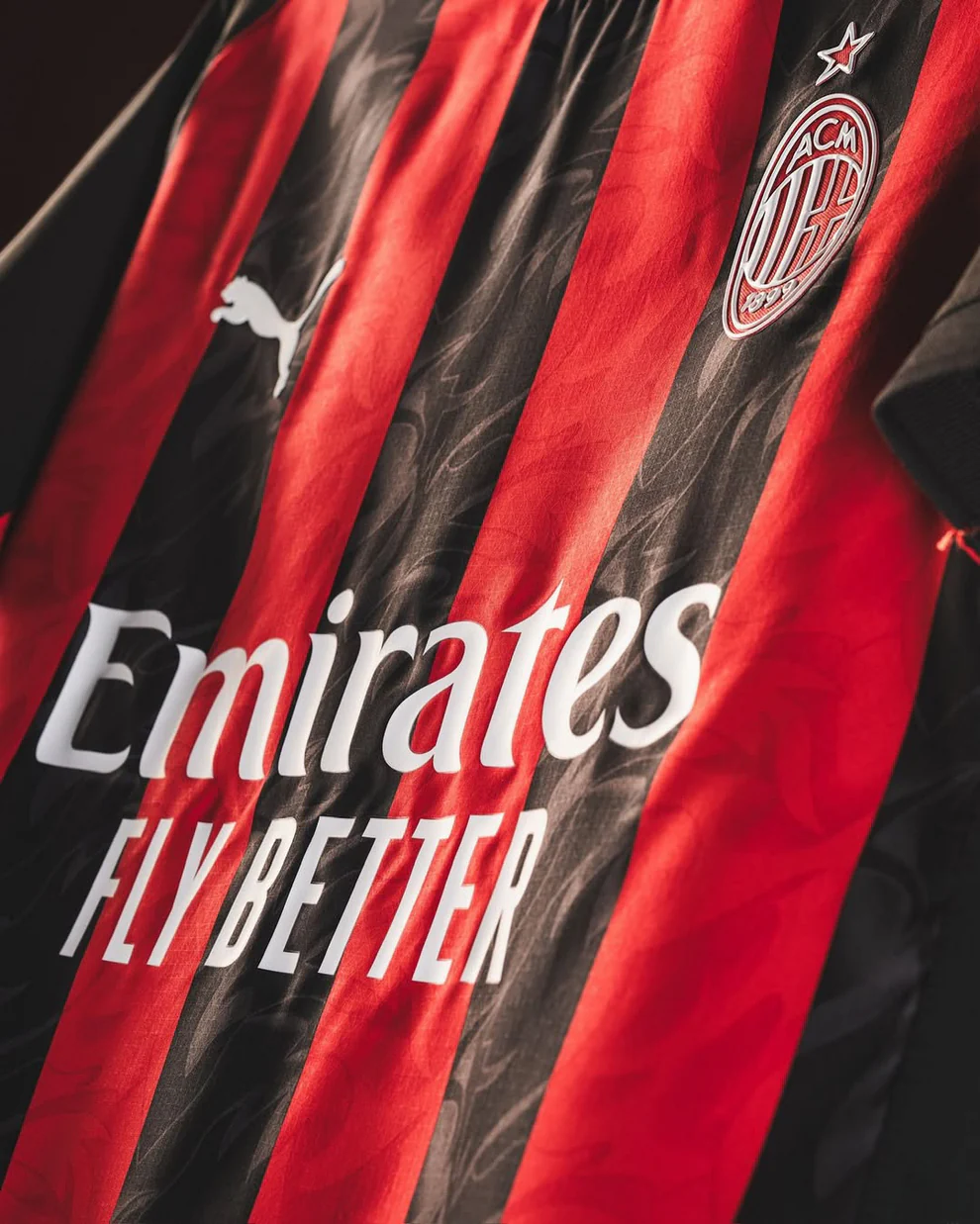AC Milan home jersey 2025-26 featuring black and red stripes with Emirates logo