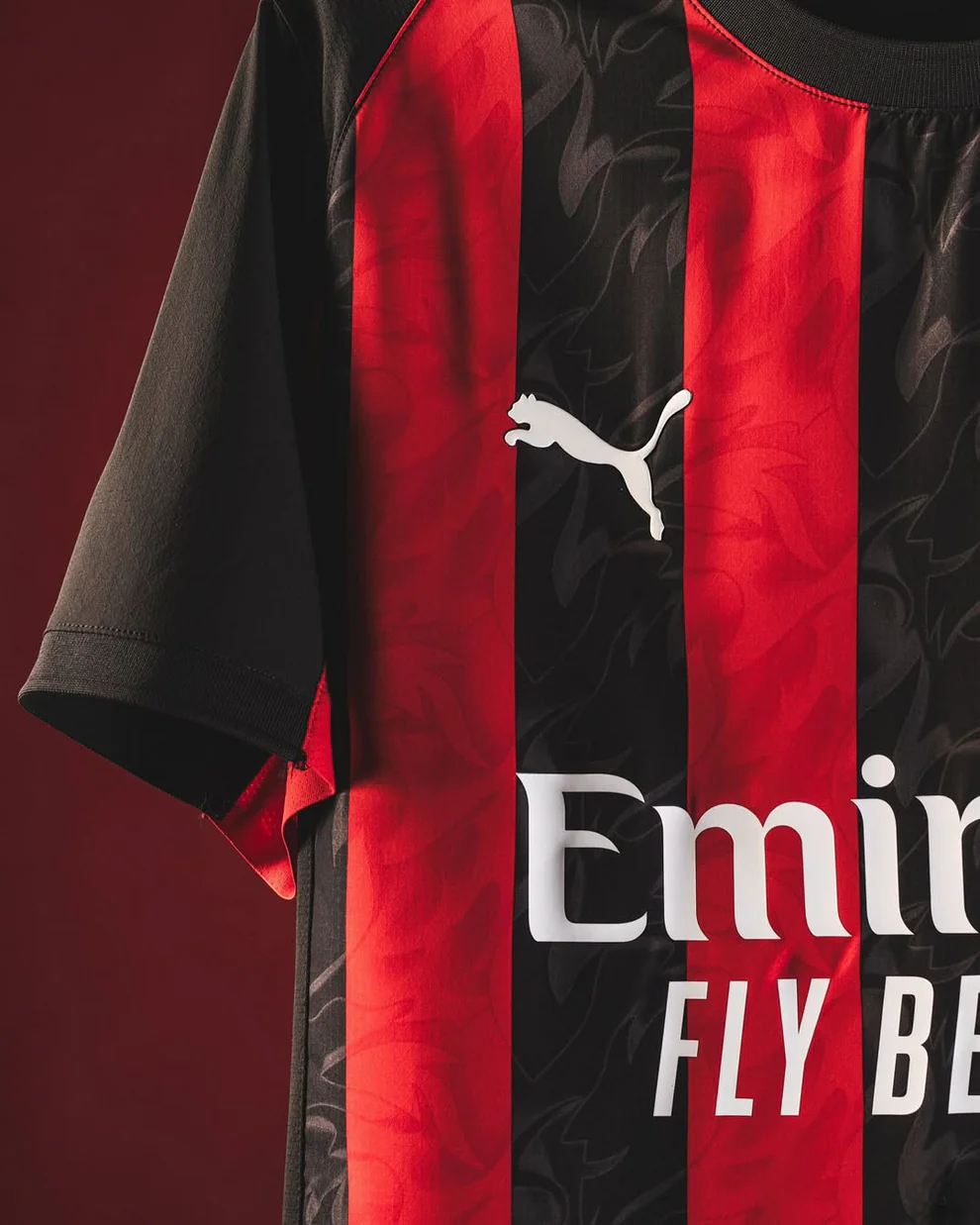 AC Milan home jersey 2025-26 featuring black and red stripes with Puma logo and Emirates sponsor
