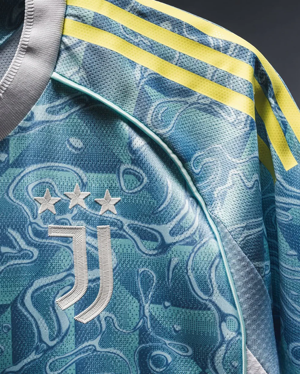 Close-up of Juventus away jersey 25-26 with blue camo pattern and yellow stripes from Hoop Store