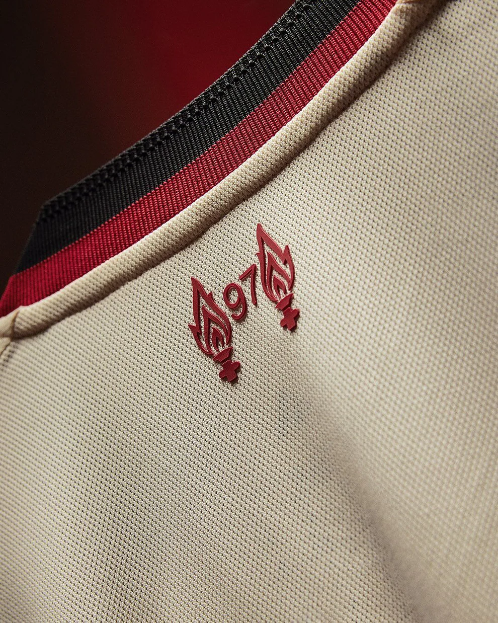 Close up of Hoop Store Liverpool Away Jersey 2025-26 beige fabric with red black collar and red 97 flame detail