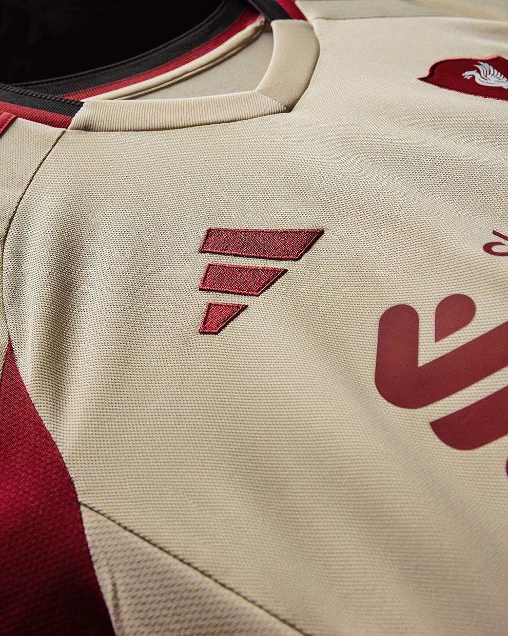 Hoop Store close up of Liverpool Away Jersey 2025-26 cream fabric with maroon trim and embroidered logos