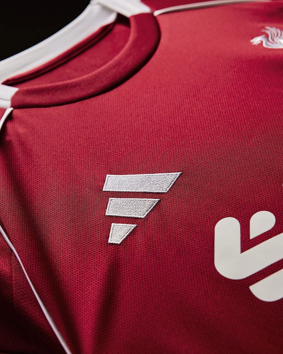 Hoop Store Liverpool home jersey 2025-26 full sleeves red close up showing white piping collar and embroidered logos