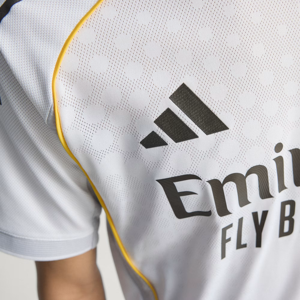 Close up of Real Madrid 2025 home jersey chest showing Adidas logo white fabric and yellow piping from Hoop Store