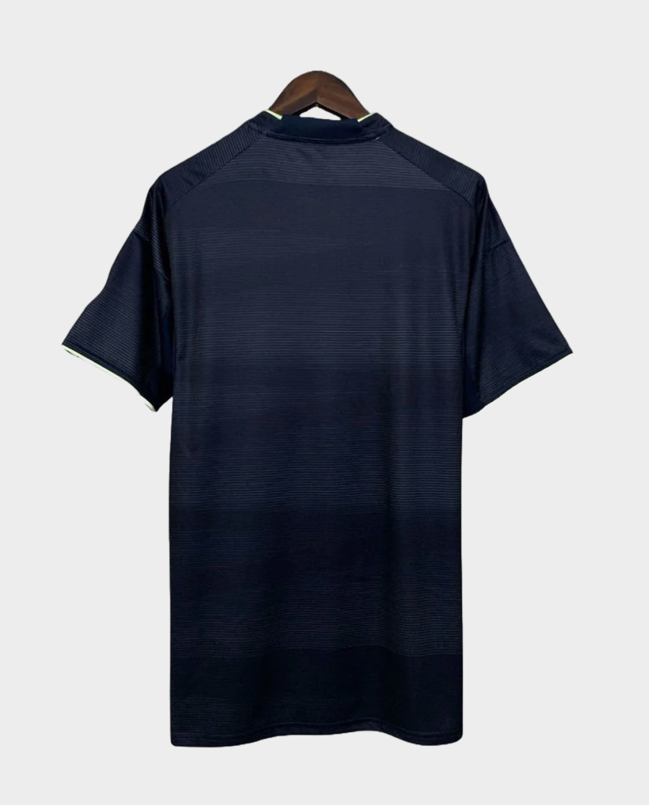 Back view of Real Madrid away jersey 2025 26 in dark color hanging on wooden hanger