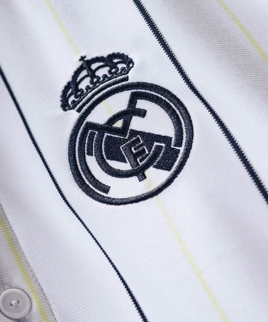 Real Madrid special edition jersey 2025-26 close up of embroidered crest on white pinstripe fabric