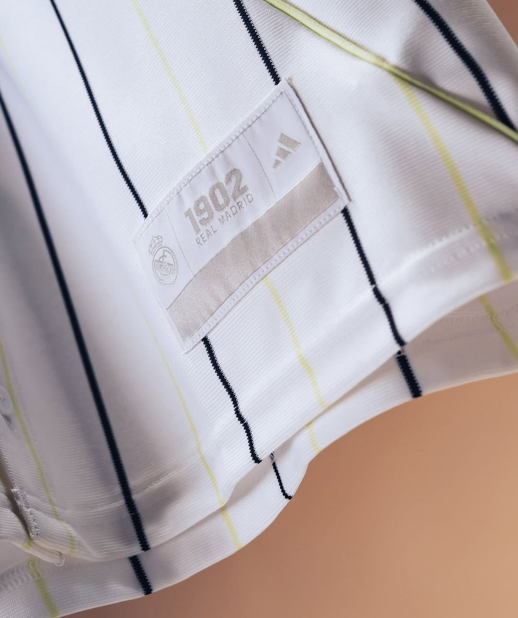 Hoop Store close up of Real Madrid special edition jersey 2025-26 white pinstripe fabric showing 1902 tag and Adidas logo