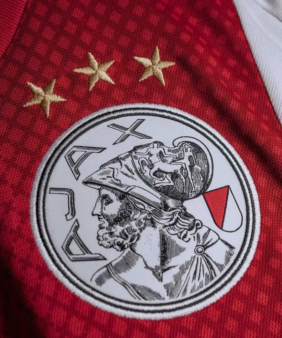Detailed view of Ajax home jersey 2025-26 player version featuring iconic logo and gold stars