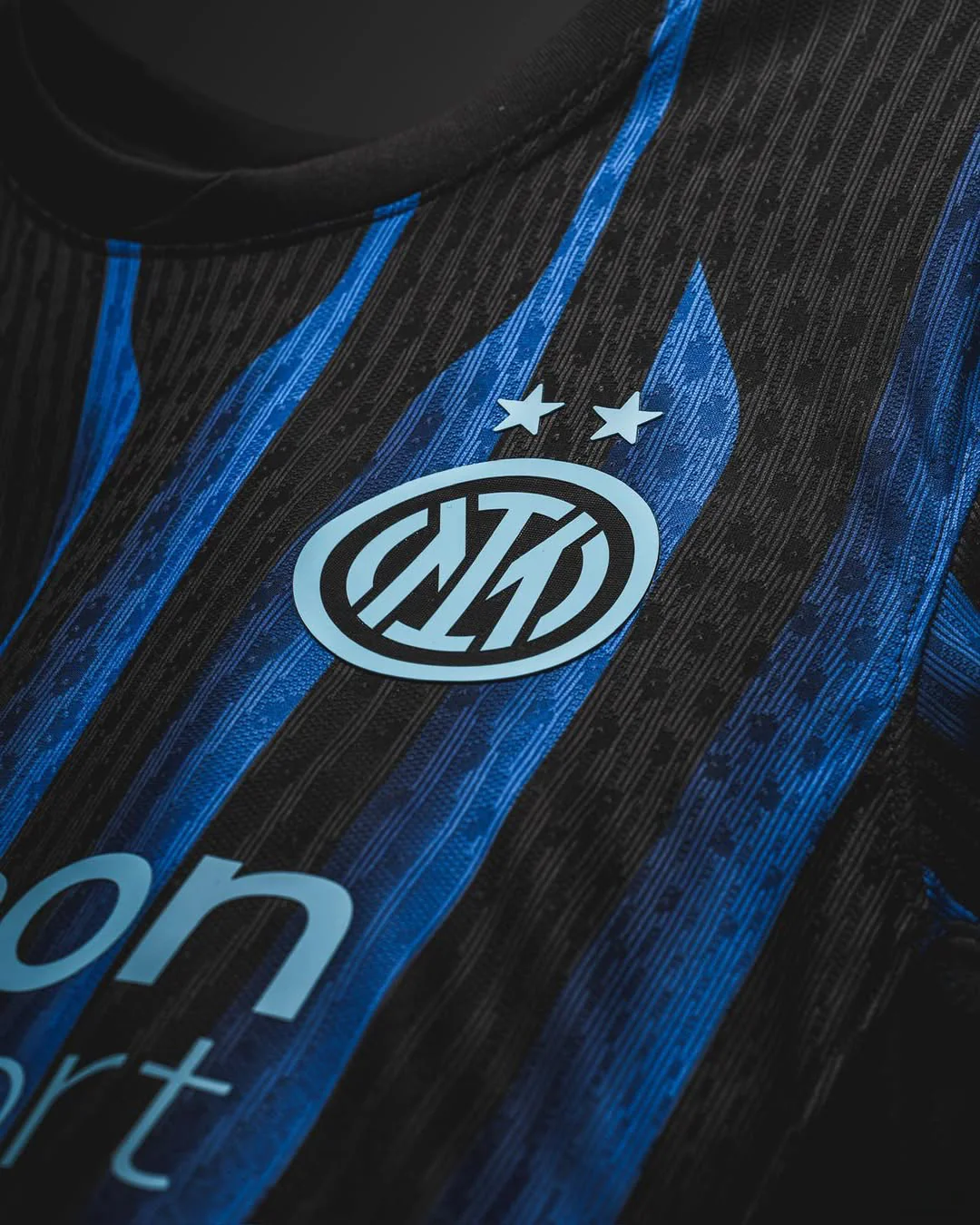 Close-up of Inter Milan 2025-26 home jersey by Hoop Store showing blue and black stripes with club logo