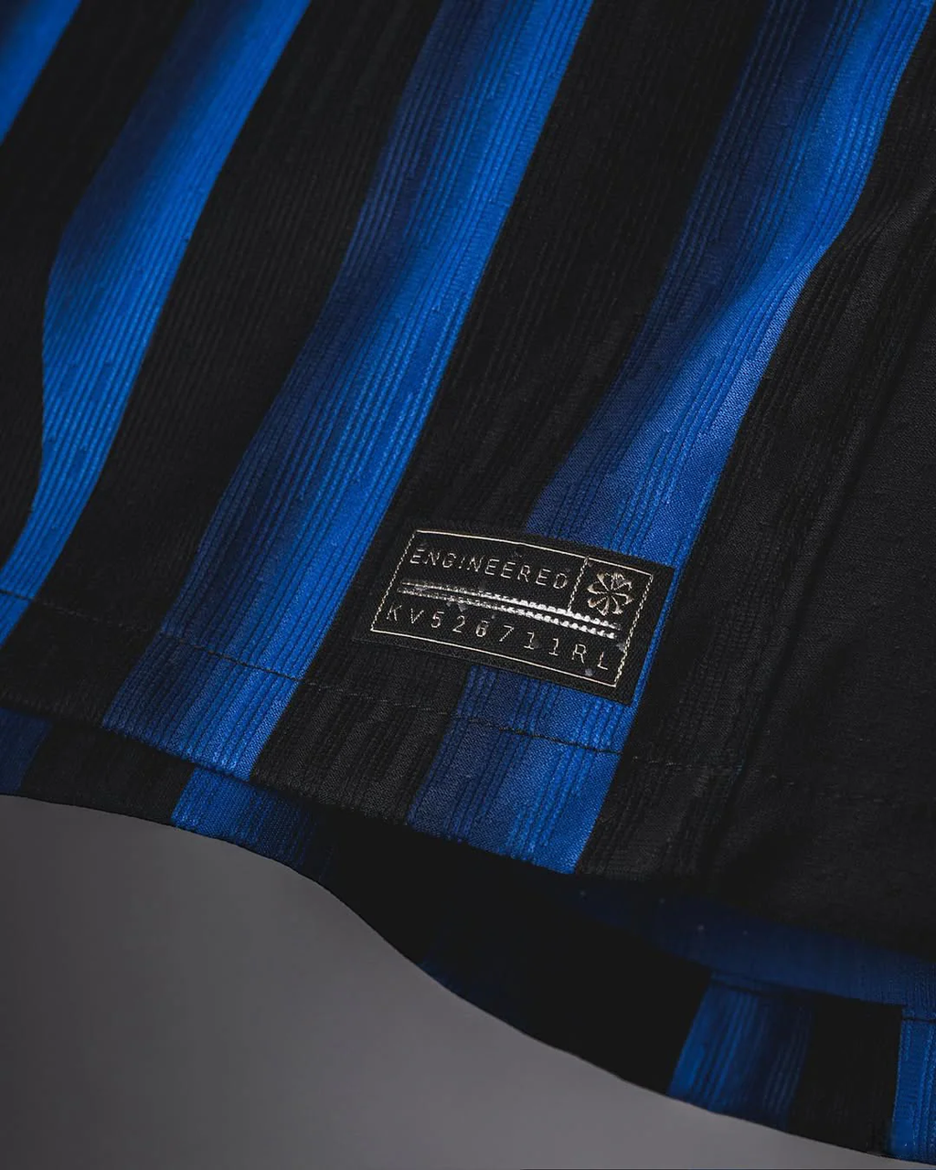 Close-up of Hoop Store Inter Milan 2025-26 home jersey fabric with blue and black stripes and engineered label