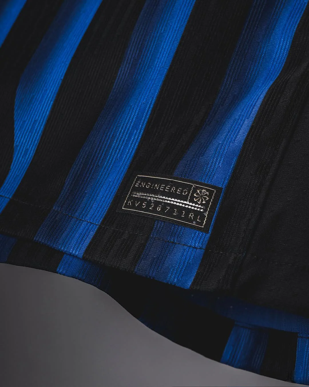 Close-up of Hoop Store Inter Milan 2025-26 home jersey fabric with blue and black stripes and engineered label