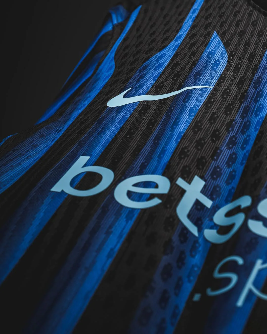 Close-up of Inter Milan 2025-26 home jersey showing blue and black stripes with Nike logo