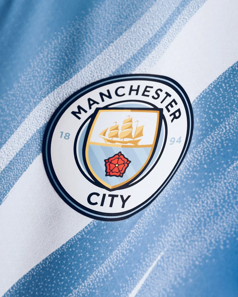 Close-up of the Manchester City 2025-26 Home Jersey logo featuring the iconic sailboat design