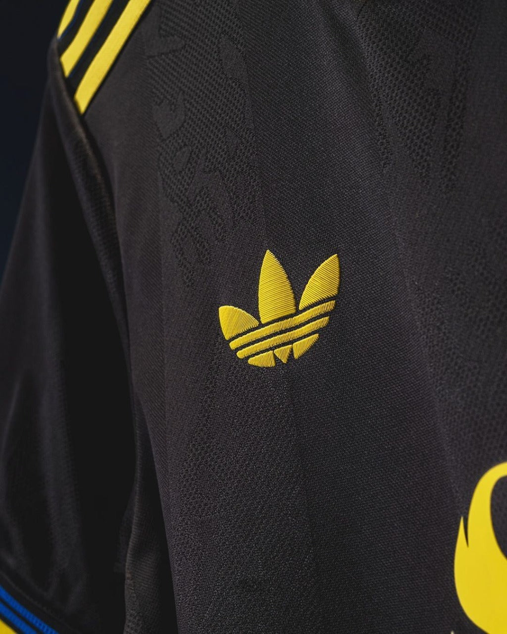 Close-up of the Adidas logo on the Manchester United third jersey 2025-26 with yellow accents