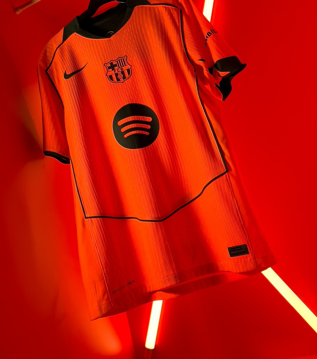 Hoop Store Barcelona third jersey 2025-26 player version orange with black trim Nike and Spotify logos against red neon