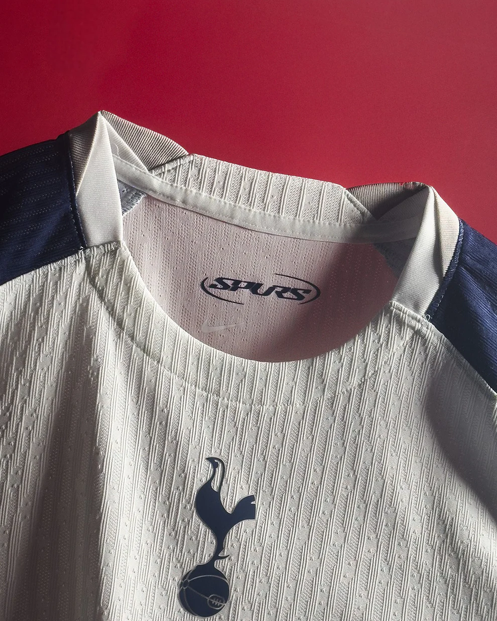 Hoop Store close up of Tottenham Hotspur 2025 home jersey white textured fabric and crest