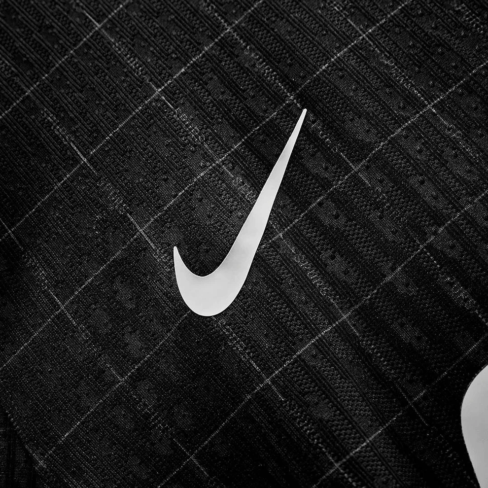 Hoop Store closeup of Tottenham Hotspur away jersey 2025-26 black fabric with white Nike swoosh and textured check pattern