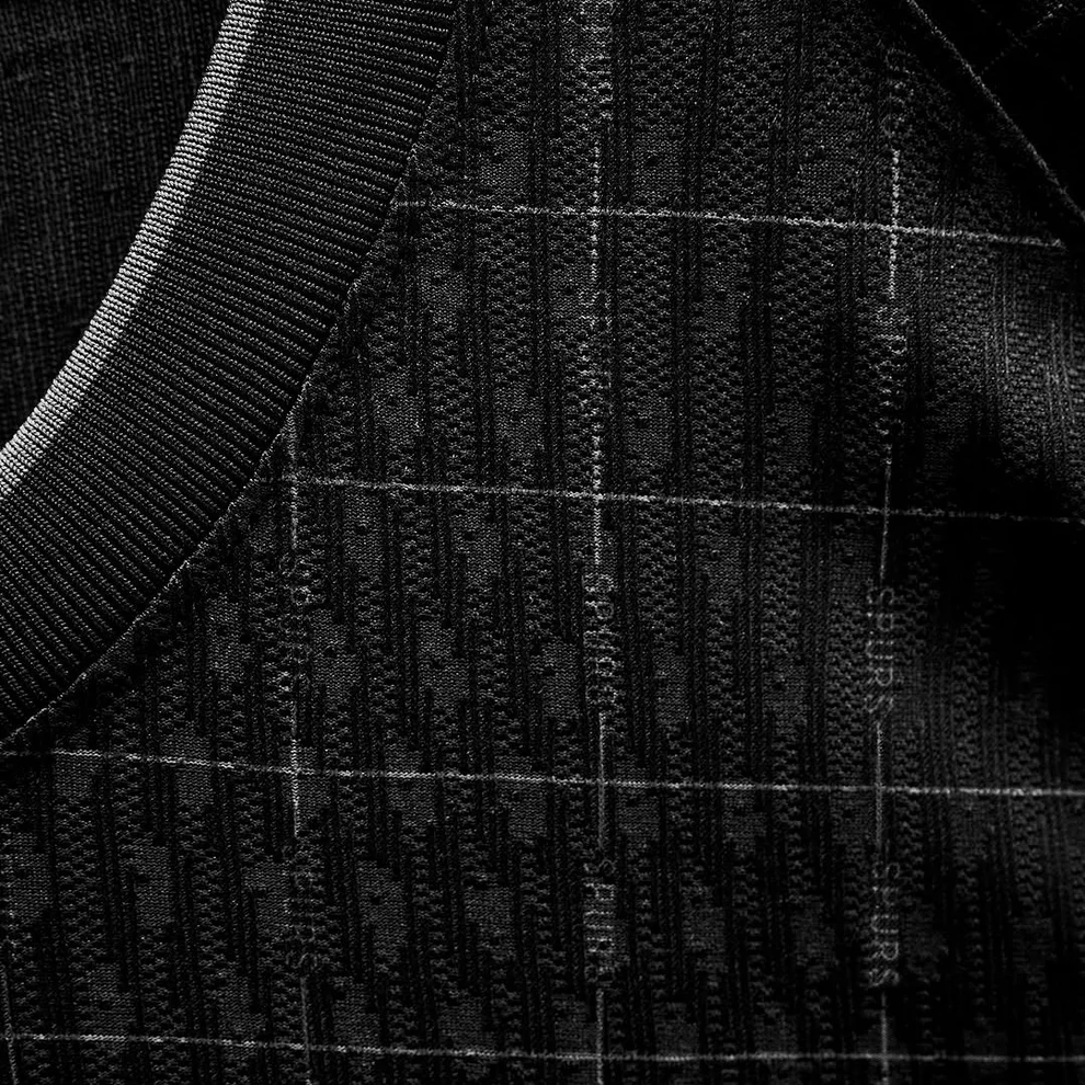 Hoop Store close up of Tottenham Hotspur away jersey 2025-26 black textured fabric with subtle grid pattern and ribbed collar