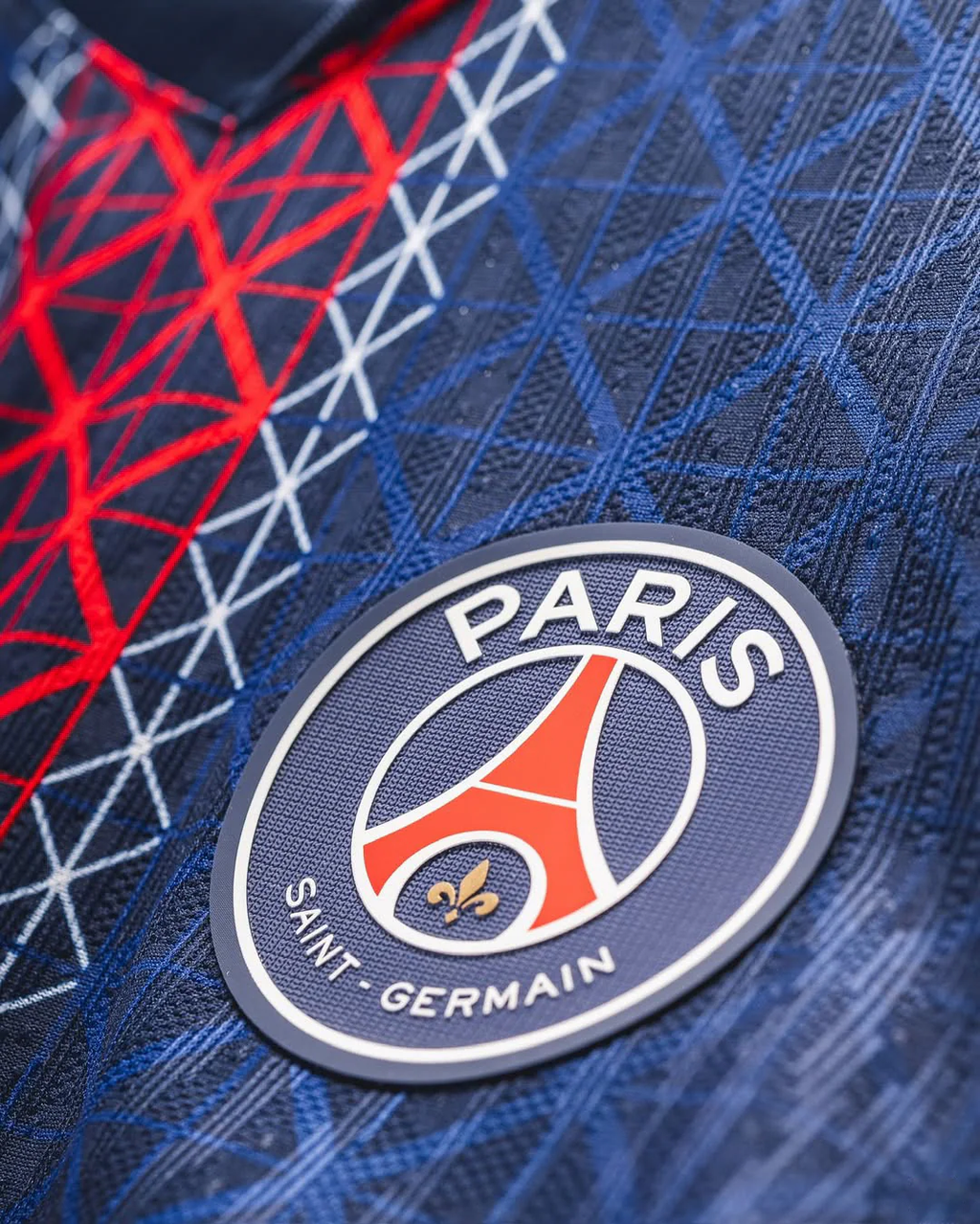 Close-up of Paris Saint-Germain badge on the blue and red Paris home jersey 2025 Player Version