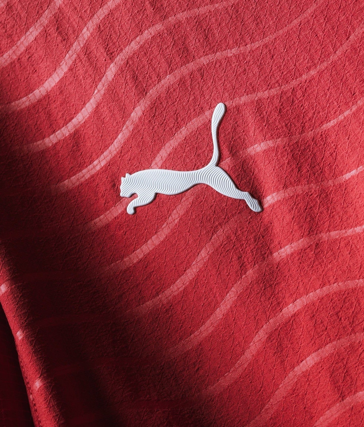 Close-up of the Puma logo on the Ronaldo Portugal 2026 FIFA home jersey in red fabric